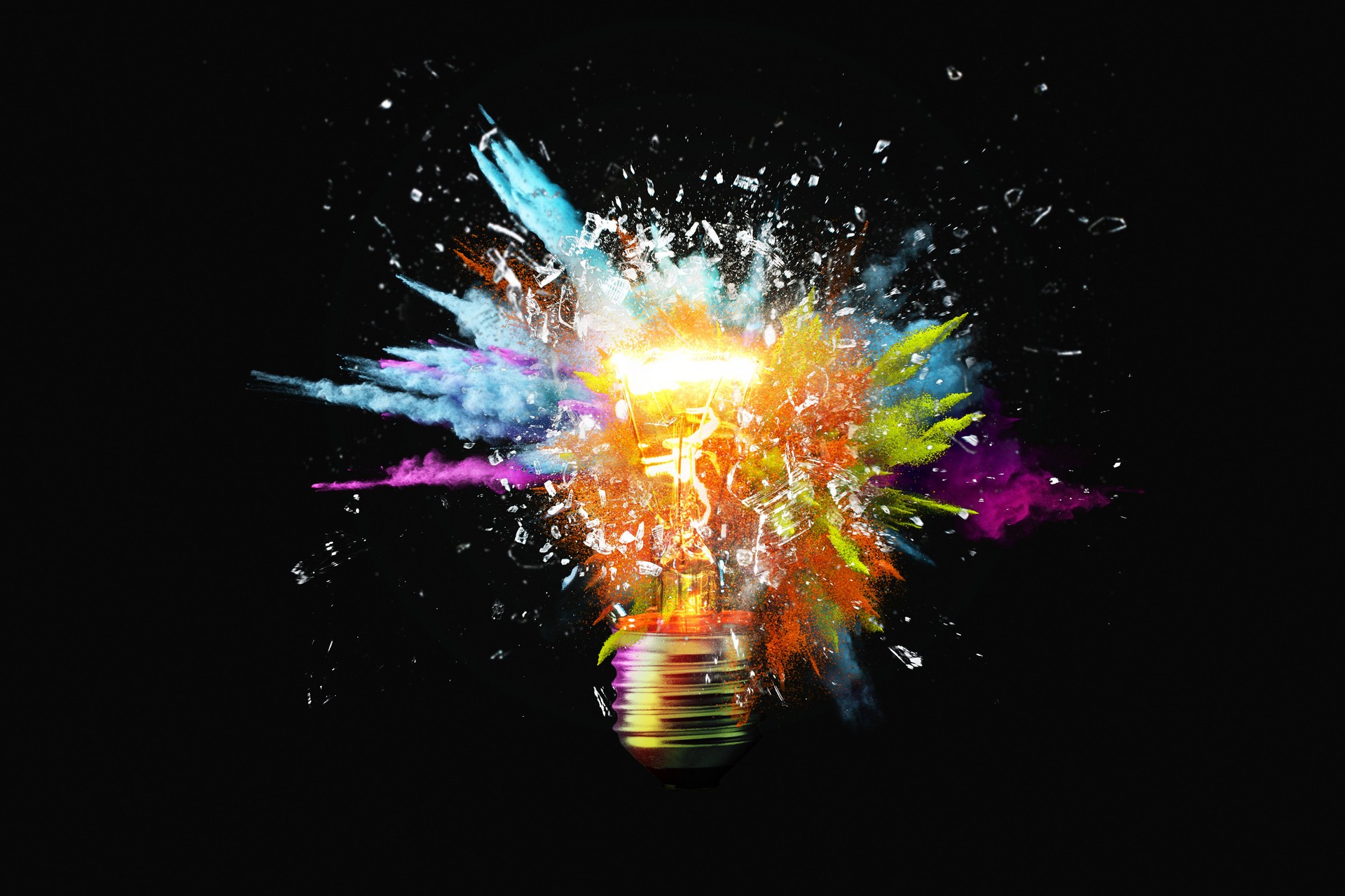 Creative light bulb explodes with colorful paint splashes and shards of glass on a black background. Think differently creative idea concept. Dry paint splatter. Brainstorm and think